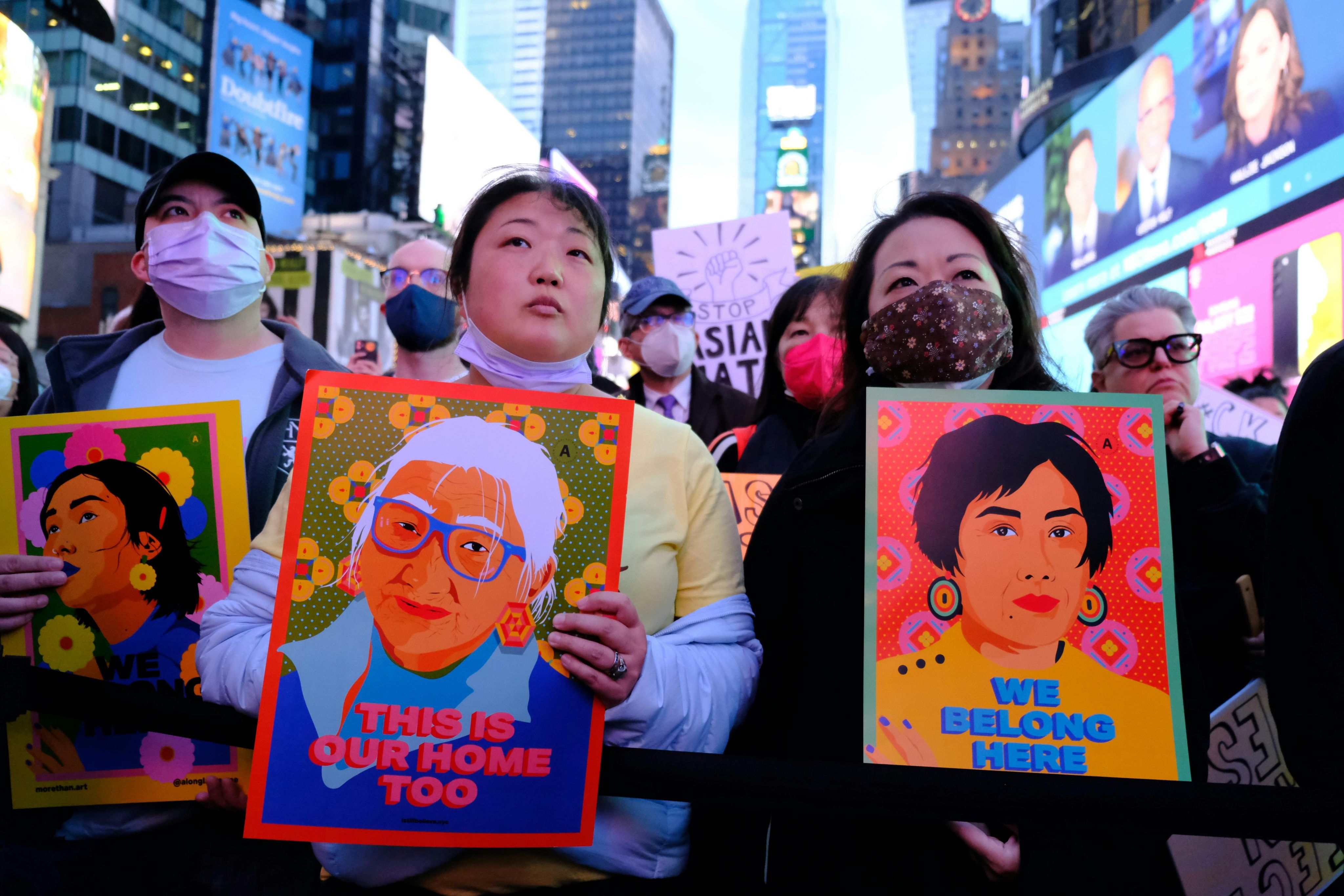 Activists hold signs reading 'This is our home too' & 'We belong here'